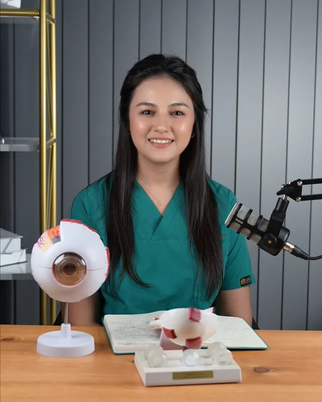 Op. Dr. İlgin Kaya, cerrahi formasıyla göz modelinin yanında